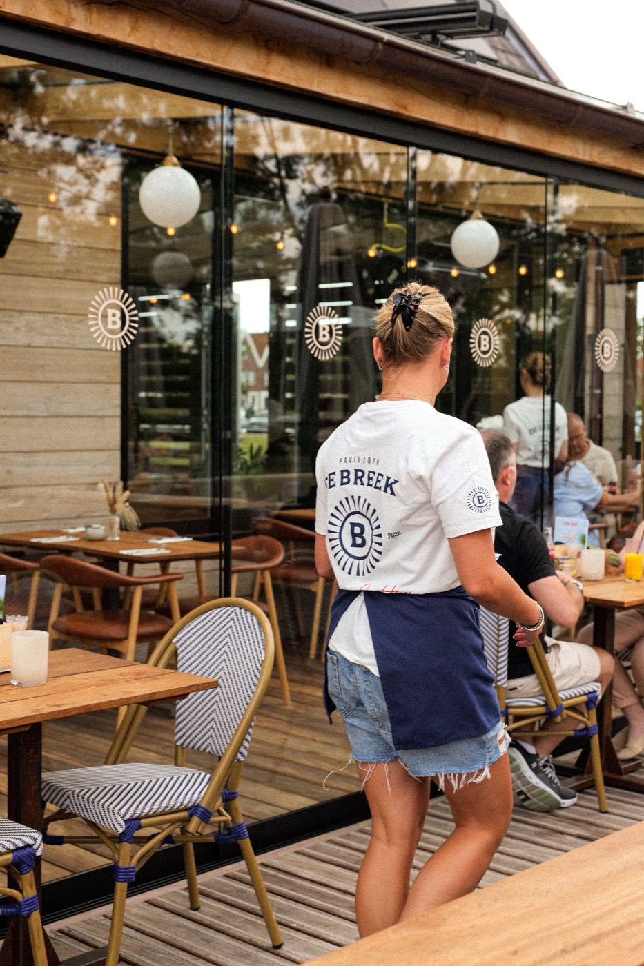 Bediening van Paviljoen De Breek op het terras, tussen de gasten